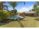 Inviting backyard pool area with a tiki bar, lounge chairs, lush landscaping, and a resort-like ambiance at 7315 W Monte Lindo Ln, Glendale, AZ 85310