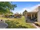Expansive backyard featuring a pool, tiki hut, covered patio, and meticulously maintained landscaping at 7315 W Monte Lindo Ln, Glendale, AZ 85310