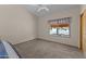 A carpeted bedroom featuring a ceiling fan and window offering natural light at 7315 W Monte Lindo Ln, Glendale, AZ 85310