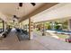 Spacious covered patio overlooking a beautifully landscaped backyard with a pool and tiki hut at 7315 W Monte Lindo Ln, Glendale, AZ 85310