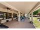 Inviting covered patio featuring ceiling fans, comfortable seating, and views of the landscaped yard at 7315 W Monte Lindo Ln, Glendale, AZ 85310