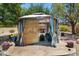 Cozy outdoor gazebo with comfortable seating and a fireplace, surrounded by lush greenery at 7315 W Monte Lindo Ln, Glendale, AZ 85310