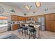 Bright kitchen with skylights, stainless steel appliances, a kitchen island, and barstool seating at 7315 W Monte Lindo Ln, Glendale, AZ 85310