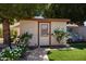 A charming backyard storage shed with a decorative window and surrounding garden at 7315 W Monte Lindo Ln, Glendale, AZ 85310