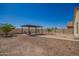 Expansive backyard featuring a pergola-covered patio area, xeriscaping, and ample space for outdoor enjoyment at 7324 S 254Th Dr, Buckeye, AZ 85326