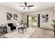 A living room featuring neutral walls, carpet, a ceiling fan, and a sliding glass door to the backyard at 7324 S 254Th Dr, Buckeye, AZ 85326