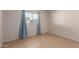 Bright bedroom has large window with light blue curtains and tile floors for easy maintenance at 7619 W Clarendon Ave, Phoenix, AZ 85033
