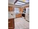 Well-lit kitchen with oak cabinets, white appliances, and tile flooring at 8161 E Keats Ave # 376, Mesa, AZ 85209