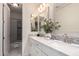 Bathroom featuring dual sinks with white cabinets and marble countertops and a tiled shower and floors at 861 E Canyon Way, Chandler, AZ 85249