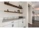Butler's pantry featuring white cabinets, stone countertops, and decorative shelves at 861 E Canyon Way, Chandler, AZ 85249