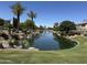 Scenic community lake with waterfall feature, mature palm trees, and lush green landscaping at 861 E Canyon Way, Chandler, AZ 85249