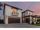 Charming home featuring a dark brown two-car garage, a balcony, stone details, and a beautiful sky at 861 E Canyon Way, Chandler, AZ 85249