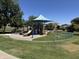 Community playground area surrounded by lush green space with neighborhood homes beyond at 861 E Canyon Way, Chandler, AZ 85249