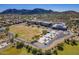 A picturesque aerial view of a school, athletic fields, and surrounding neighborhood nestled against the backdrop of scenic mountains at 8687 W Bajada Rd, Peoria, AZ 85383