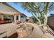 Backyard featuring outdoor seating, a stone fireplace and desert landscaping at 8687 W Bajada Rd, Peoria, AZ 85383
