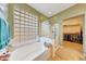 Bright bathroom featuring a soaking tub with glass block window and a glass enclosed shower at 8687 W Bajada Rd, Peoria, AZ 85383