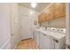 Well-lit laundry room with white front load washer and dryer and tile flooring at 8687 W Bajada Rd, Peoria, AZ 85383