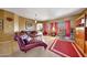 Comfortable living room with a tufted chaise lounge, plush seating, and bright red accents at 8687 W Bajada Rd, Peoria, AZ 85383