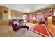 Comfortable living room with a tufted chaise lounge, plush seating, and bright red accents at 8687 W Bajada Rd, Peoria, AZ 85383