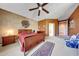 Large main bedroom with ceiling fan, plush carpet, and decorative art features at 8687 W Bajada Rd, Peoria, AZ 85383
