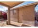 Backyard entrance has a simple tan door, brick floor, and bougainvillea shrubs at 940 S Revere --, Mesa, AZ 85210