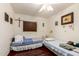 Functional bedroom with twin beds, hardwood floors, a ceiling fan and natural light at 940 S Revere --, Mesa, AZ 85210