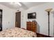 This bedroom features dark wood floors, ceiling fan, TV, and dresser for storage at 940 S Revere --, Mesa, AZ 85210