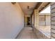 Covered porch with tile flooring and a brick accent wall at 940 S Revere --, Mesa, AZ 85210