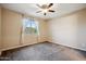 Cozy bedroom features neutral walls, carpet floors, and a bright window with sheer curtains at 9921 E Acceleration Dr, Mesa, AZ 85212