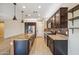 Gourmet kitchen boasts granite countertops, dark wood cabinets, and stainless steel appliances at 9921 E Acceleration Dr, Mesa, AZ 85212