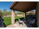 Inviting covered patio with outdoor seating and views of the private backyard with lush artificial turf at 10284 E Mallow Cir, Scottsdale, AZ 85255