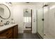 Stylishly renovated bathroom showcasing a new vanity, walk-in shower, and arched doorway leading to the bedroom at 10284 E Mallow Cir, Scottsdale, AZ 85255