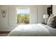 Bright bedroom featuring a window view, neutral color palette, white comforter, and stylish decor at 10284 E Mallow Cir, Scottsdale, AZ 85255