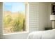 Relaxing bedroom view of desert landscape through shuttered window with mountains in the background at 10284 E Mallow Cir, Scottsdale, AZ 85255