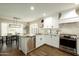 Bright kitchen boasts white cabinets, granite countertops, stainless steel appliances, and wood flooring at 10284 E Mallow Cir, Scottsdale, AZ 85255