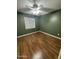 Bright bedroom featuring wood-look floors and a window with blinds at 11221 N 91St Dr, Peoria, AZ 85345