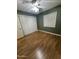 A spacious bedroom with laminated wood flooring, a ceiling fan, and a closet at 11221 N 91St Dr, Peoria, AZ 85345