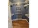 Walk-in closet featuring open shelving and wood-look flooring at 11221 N 91St Dr, Peoria, AZ 85345