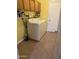 Laundry room with washer and dryer, tile floors, and wooden cabinets at 11221 N 91St Dr, Peoria, AZ 85345