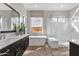 Bright bathroom featuring a soaking tub, frameless shower, and double vanity with modern finishes at 1145 E Gleneagle Dr, Chandler, AZ 85249