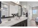 Bathroom featuring double sinks, dark wood cabinets, and access to a walk-in shower at 1145 E Gleneagle Dr, Chandler, AZ 85249