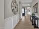 Long hallway featuring paneled walls, wood-look tile flooring, and black accent furniture at 1145 E Gleneagle Dr, Chandler, AZ 85249