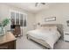 Well-lit bedroom with a neutral color scheme, plantation shutters, and ceiling fan at 1161 N Cole Dr, Gilbert, AZ 85234
