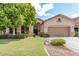 Inviting single-story home featuring a neutral stucco facade, mature landscaping, and a two-car garage at 1161 N Cole Dr, Gilbert, AZ 85234