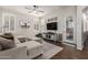 Bright living space featuring a sectional sofa, wood floors, and large windows with shutters at 1161 N Cole Dr, Gilbert, AZ 85234