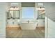 Luxurious bathroom featuring a freestanding tub, dual sinks, modern fixtures, and bright natural lighting at 1180 E Peach Tree Dr, Chandler, AZ 85249