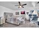 Spacious bedroom featuring a ceiling fan, TV, neutral carpet, and light-colored walls at 12022 W Belmont W Dr, Avondale, AZ 85323
