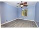 Bright bedroom features modern ceiling fan, window, and gray wood-look flooring at 13012 N 26Th Dr, Phoenix, AZ 85029