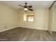 Bright bedroom features modern ceiling fan, closet, and gray wood-look flooring at 13012 N 26Th Dr, Phoenix, AZ 85029