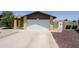 View of the front of the house and the two-car garage with a long, wide driveway at 13012 N 26Th Dr, Phoenix, AZ 85029
